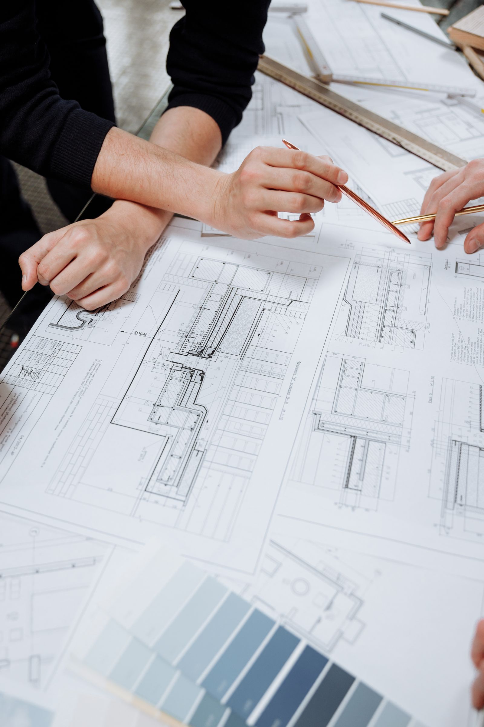 Professionals reviewing architectural plans and site layout drawings